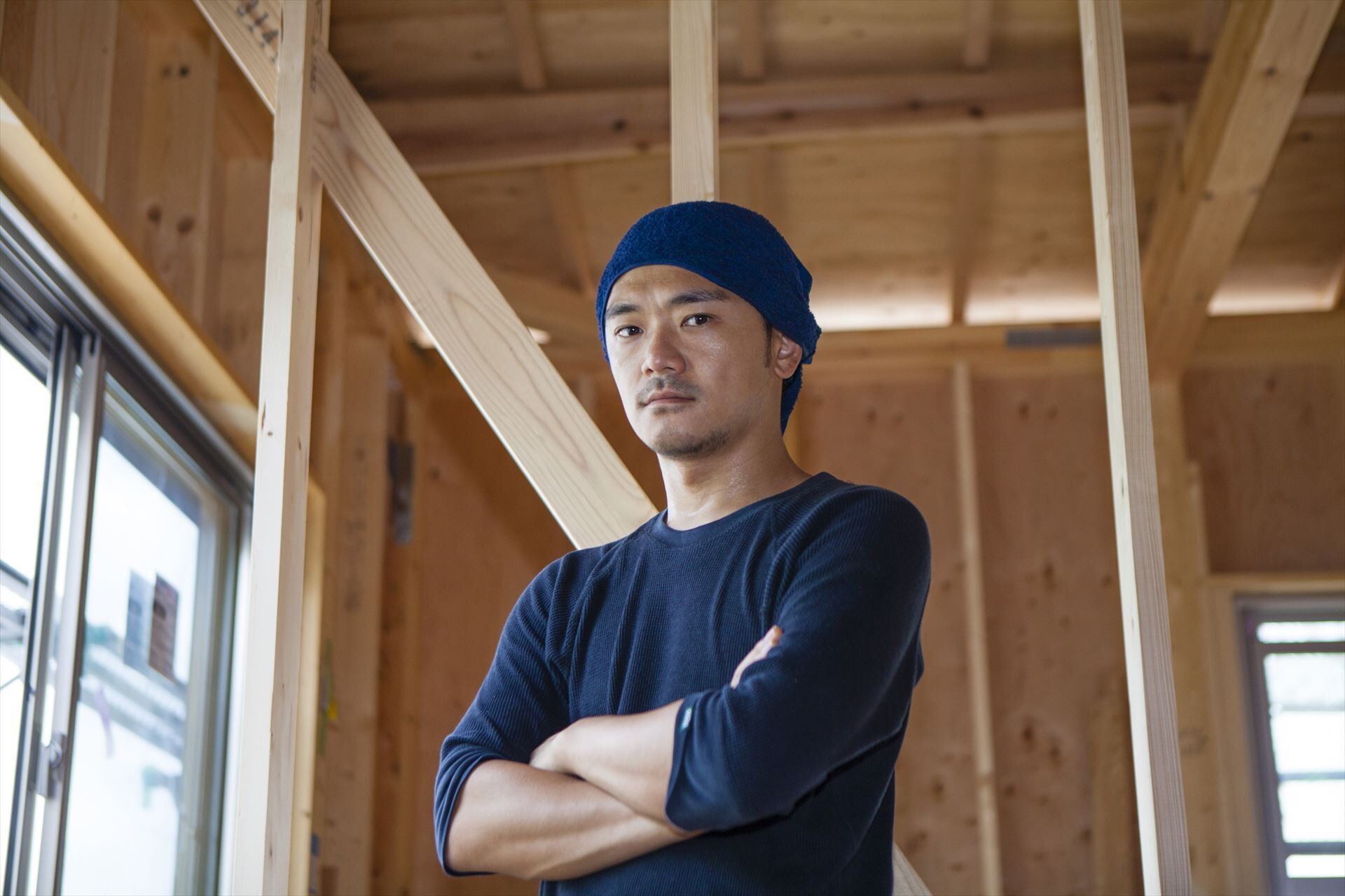 腕組みする大工